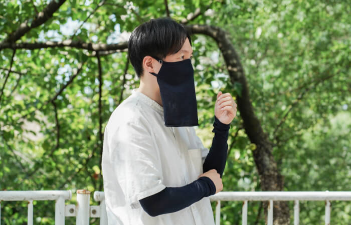 紺色の冷感シルクアームカバーとフェイスカバーを着用した男性スタッフ